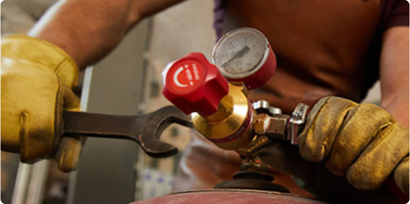 Technician loosening a compressed air tank.